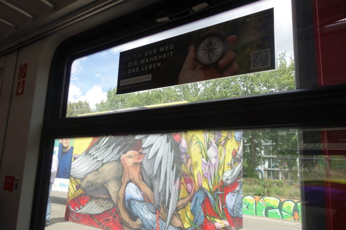 "Ich bin des Weg, die Wahreit, das Leben"  "Je suis le chemin, la vérité, et la vie"  — Pub chrétienne sur une baie vitrée d'un train de banlieue — Stuttgart —