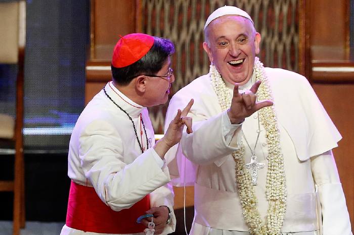 Le pape François 1er en visite aux Philippines flashant le salut de Satan