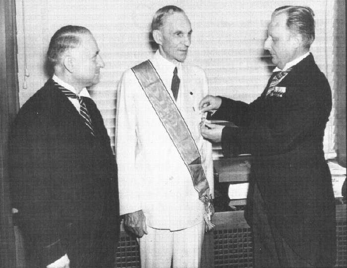 Henry Ford recevant sa décoration des mains de Karl Kapp consul à Cleveland (gauche) et Fritz Hailer consul à Detroit (droite)