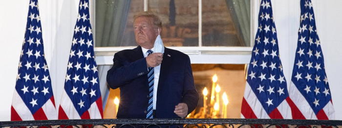 Donald Trump, de retour la Maison Blanche, enlève son masque, le 5 octobre 2020, à Washington.   (WIN MCNAMEE / GETTY IMAGES NORTH AMERICA / AFP)