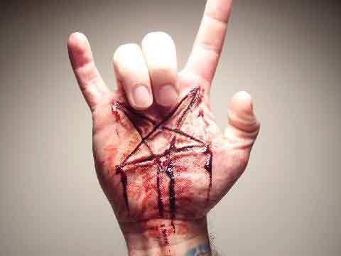 Salut cornu dévoilant l'étoile de Satan, une marque scarifiée sur la main droite 