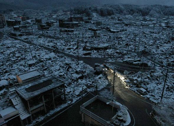 Véhicule circulant de nuit dans un village côtier après le passage du tsunami 