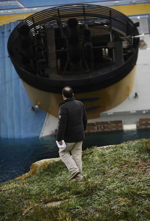 Insulaire devant la cheminée du Costa Concordia photographié après le naufragev