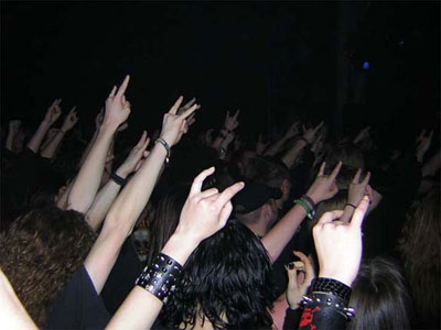 la "main cornue" (ou le "salut cornu") est brandie par les participants aux concerts