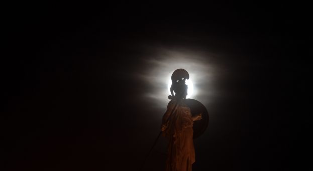 Silhouette de statue sur fond de pleine lune