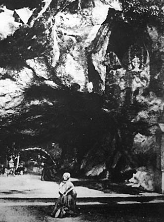 Photo de Bernadette Soubirous à la grotte de Lourdes en 1863,   cinq ans après les premières apparitions.