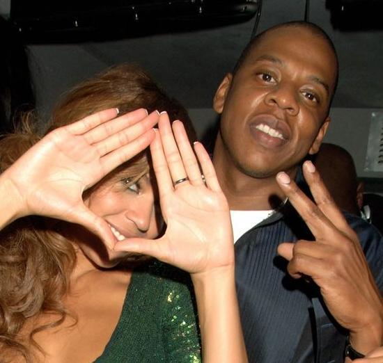 Jay-Z et son "Y" avec sa femme Beyoncé Knowles flashant le signe pyramidal